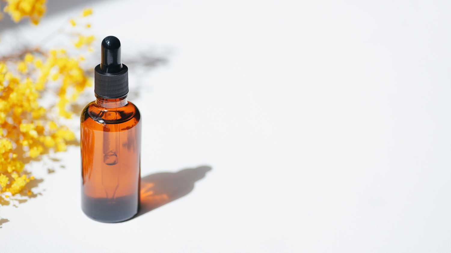 Alpha hydroxy acid serum bottle on white surface
