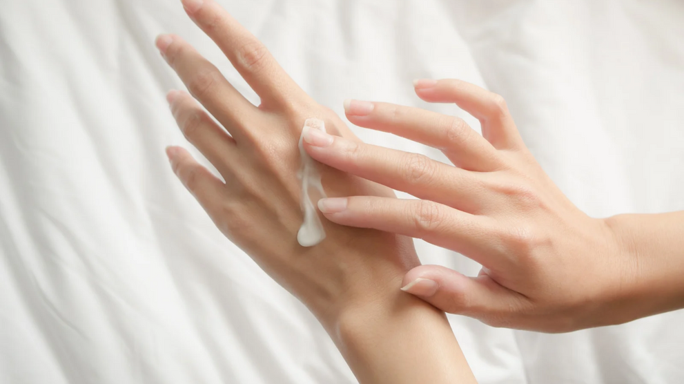 Applying hand cream to moisturize dry skin