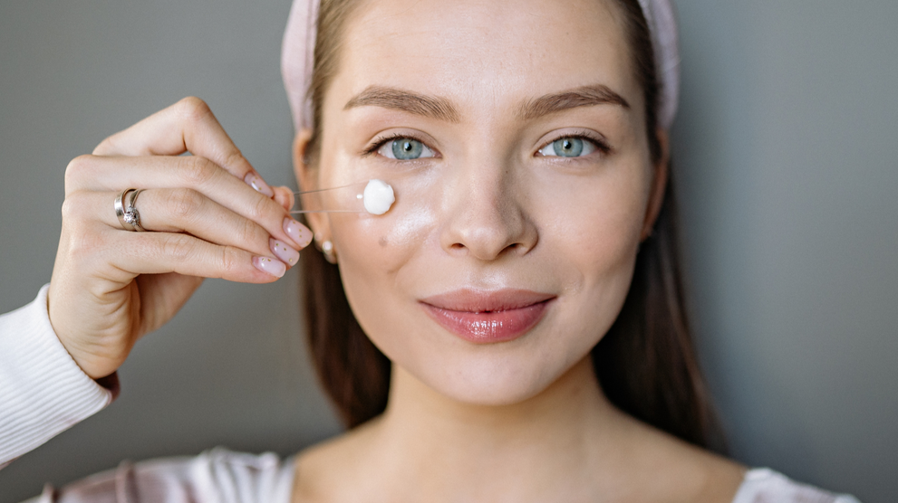 Applying retinol cream to facial skin