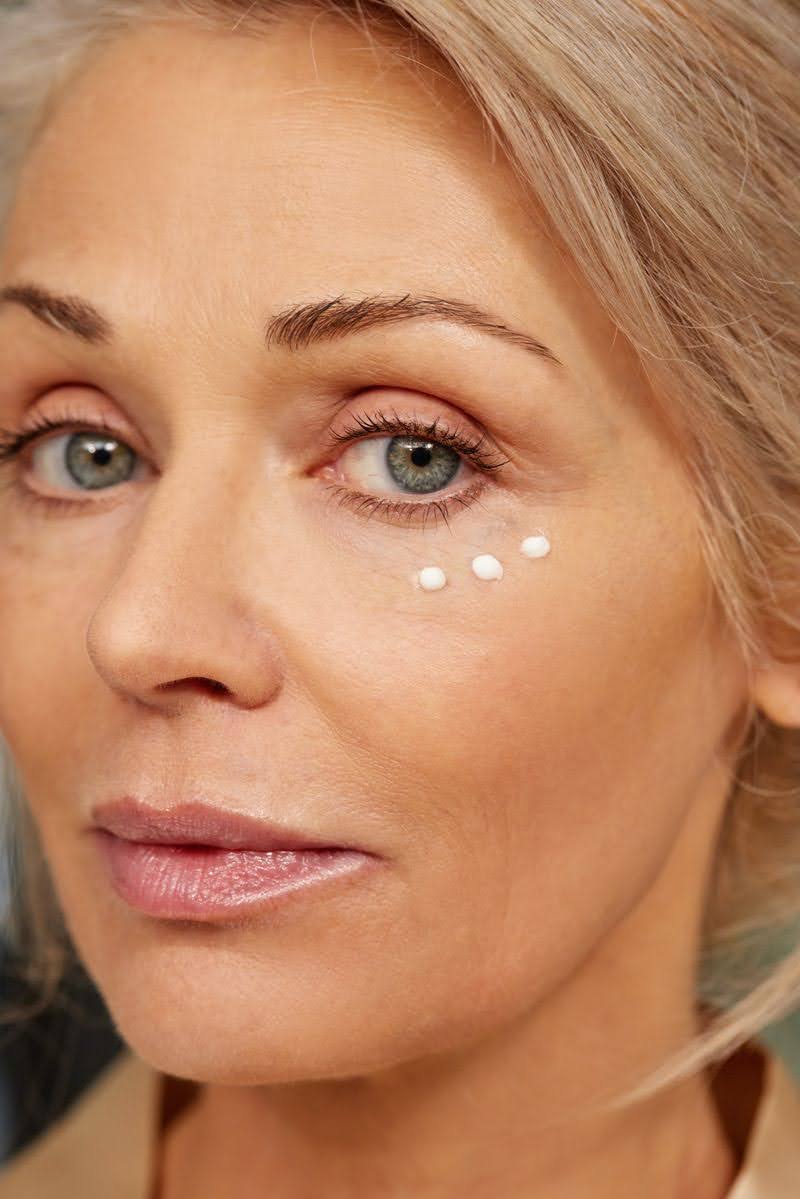 Applying retinol eye cream under the eyes
