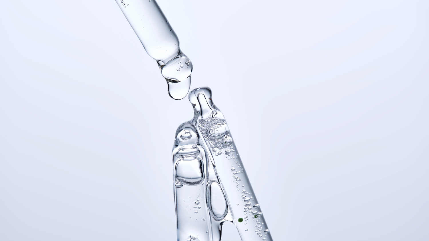 Clear glycerin serum dripping from a glass dropper