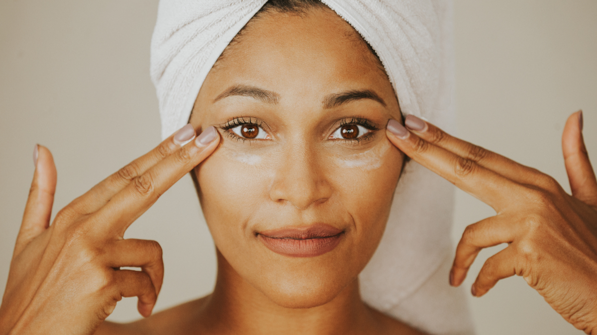 Woman applying anti-aging eye cream under eyes