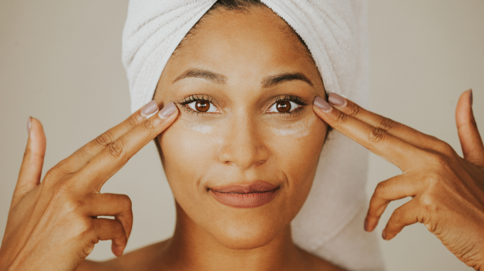 Woman applying anti-aging eye cream under eyes