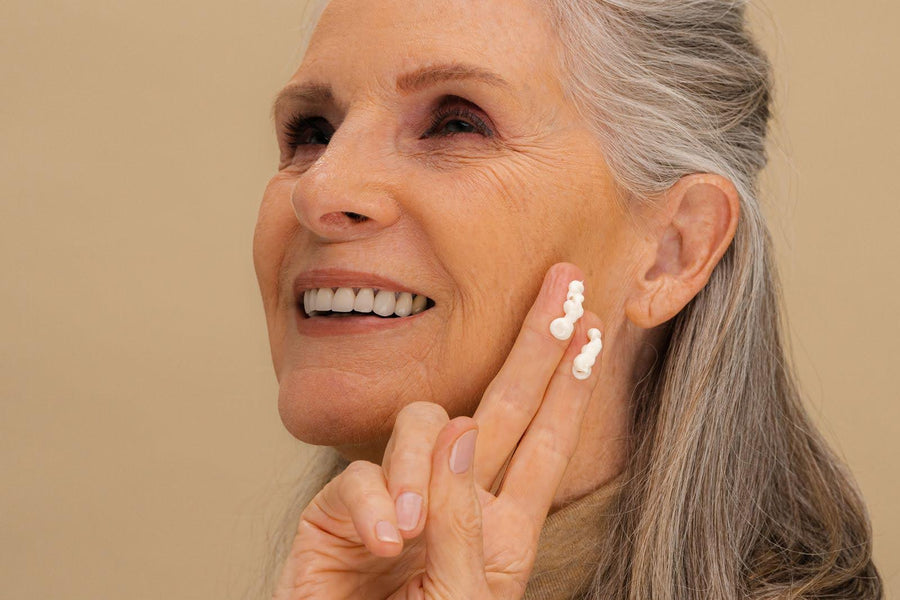 Woman applying retinol cream to face