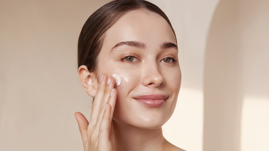 Woman applying skincare cream to reduce visible pores