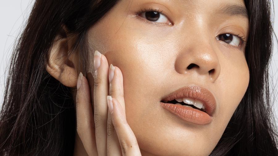 Woman applying skincare to face in summer